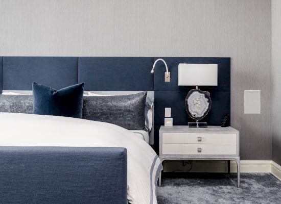 Modern bedroom with a blue and grey color scheme, featuring a bed, pillows,